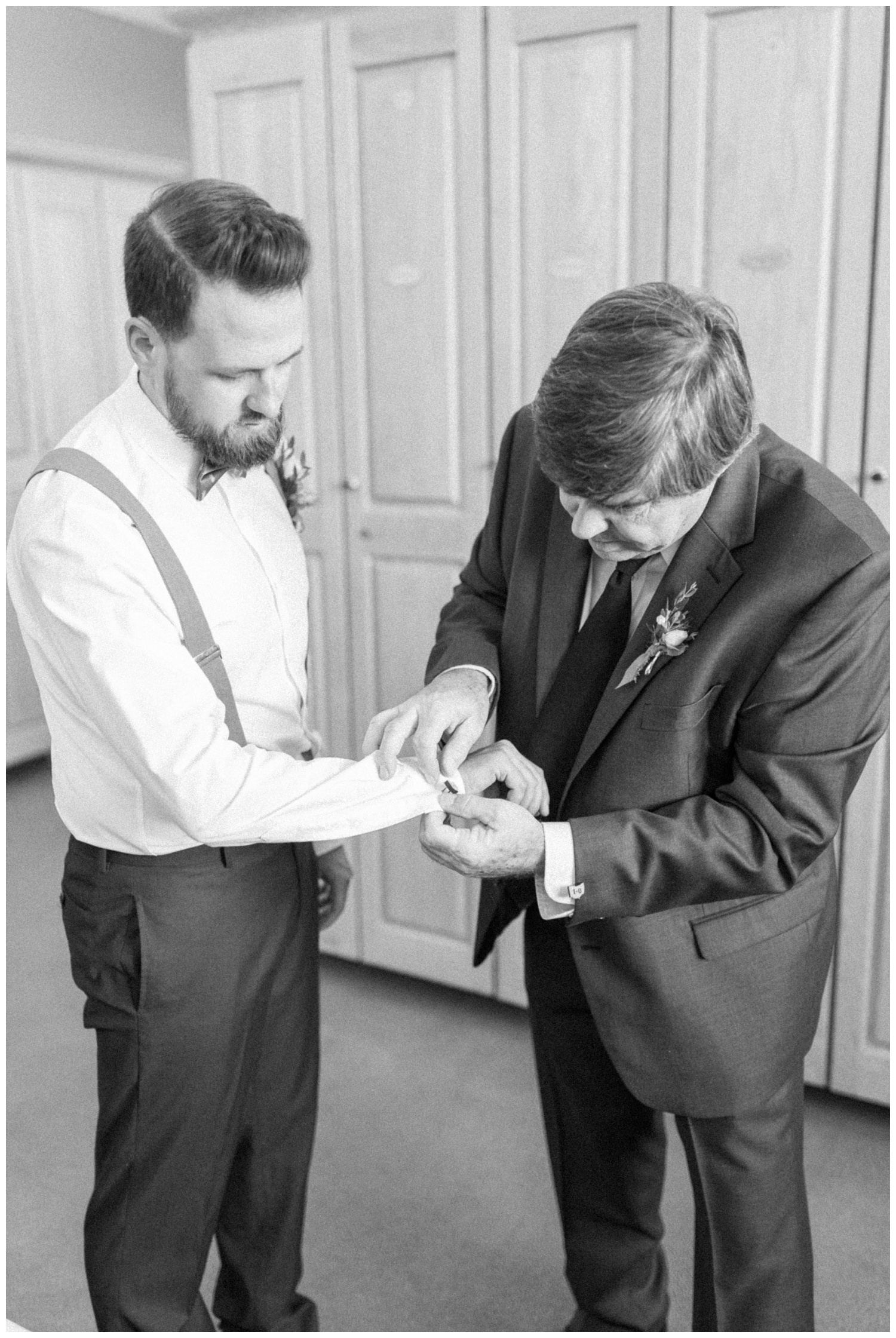 Father of groom helping groom put on cuff links at Isla Del Sol